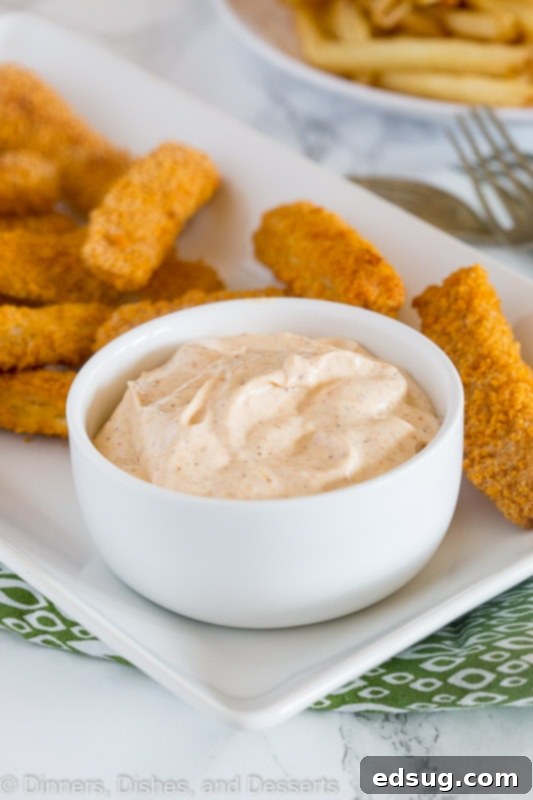 Cajun Kick Dipping Sauce 4 A platter of crunchy fish sticks with a bowl of vibrant Cajun dipping sauce