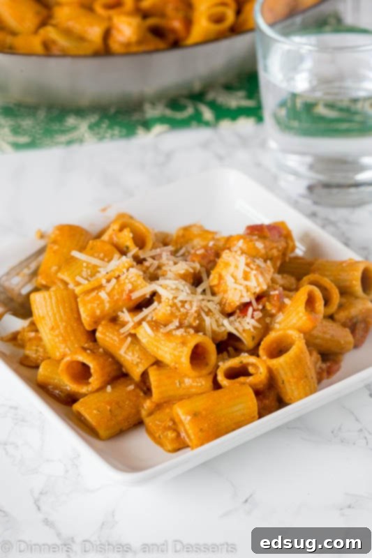 Italian Bruschetta Chicken Pasta - featuring tender, seasoned chicken and diced tomatoes in a rich pesto sauce, ideal for a quick and satisfying dinner. Close-up of Italian chicken pasta, showcasing the diced chicken and tomatoes mixed with pesto sauce, highlighting the vibrant colors and textures.