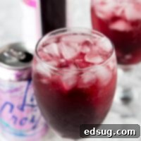 A close up of a wine glass filled with berry red wine spritzer