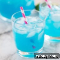 A cup of blue margarita with a straw