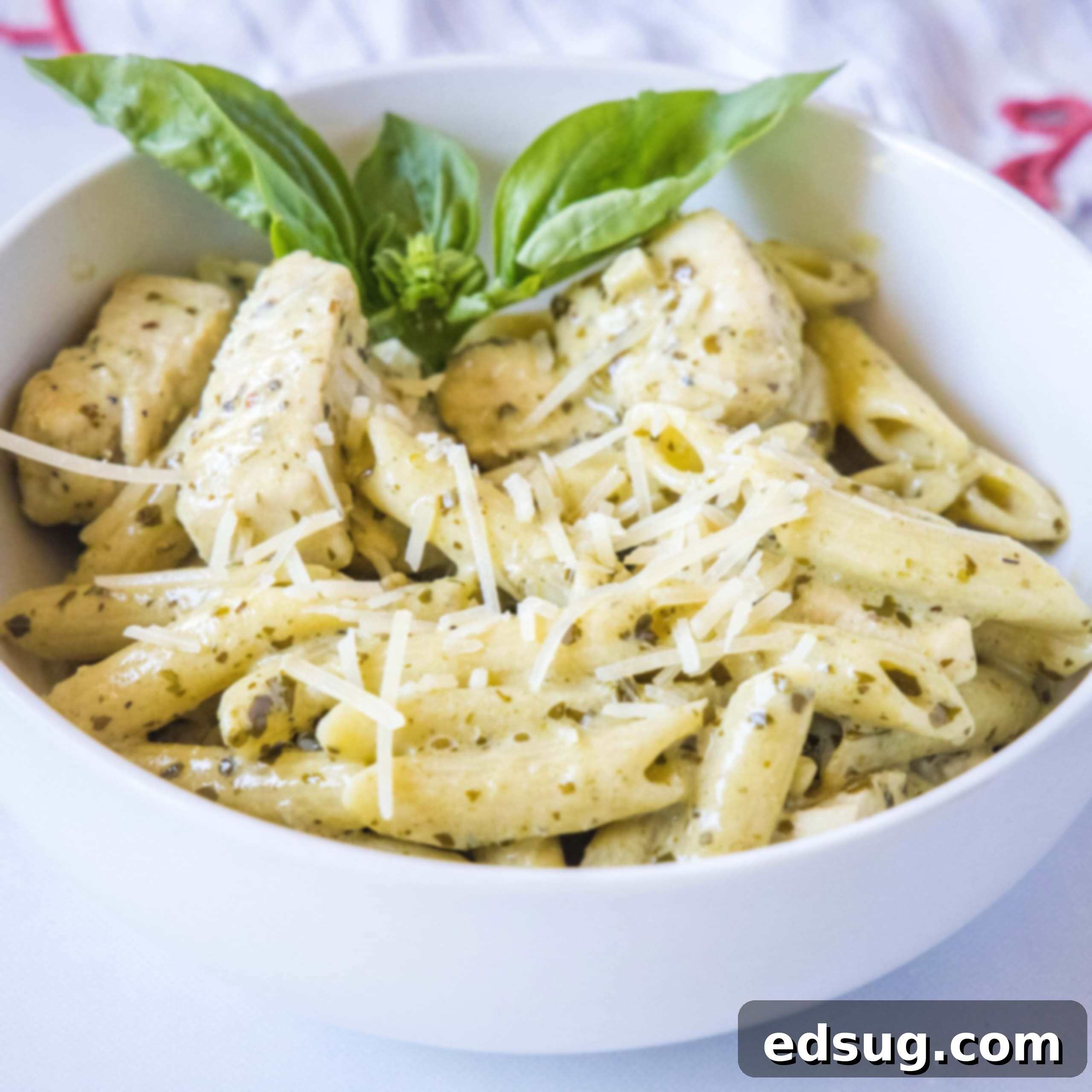 cropped close up of chicken pesto pasta in a white bowl