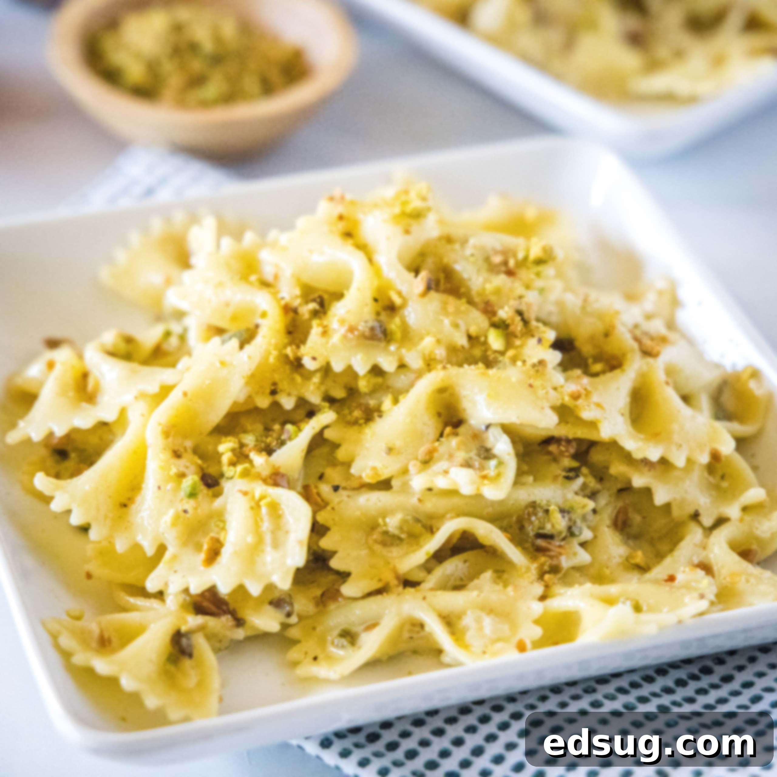 square image of pistachio pasta on a white plate