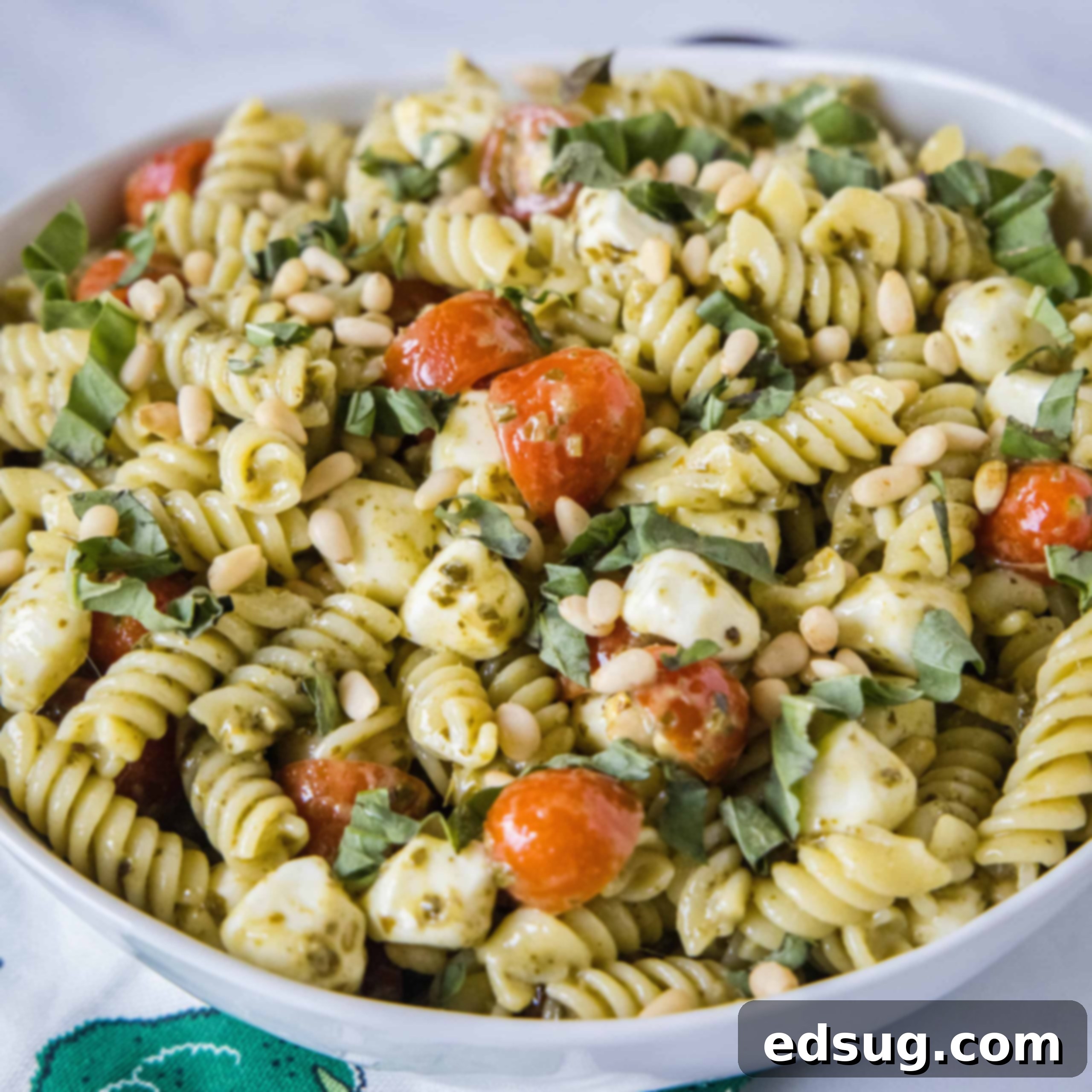 close up pesto pasta salad in a white bowl
