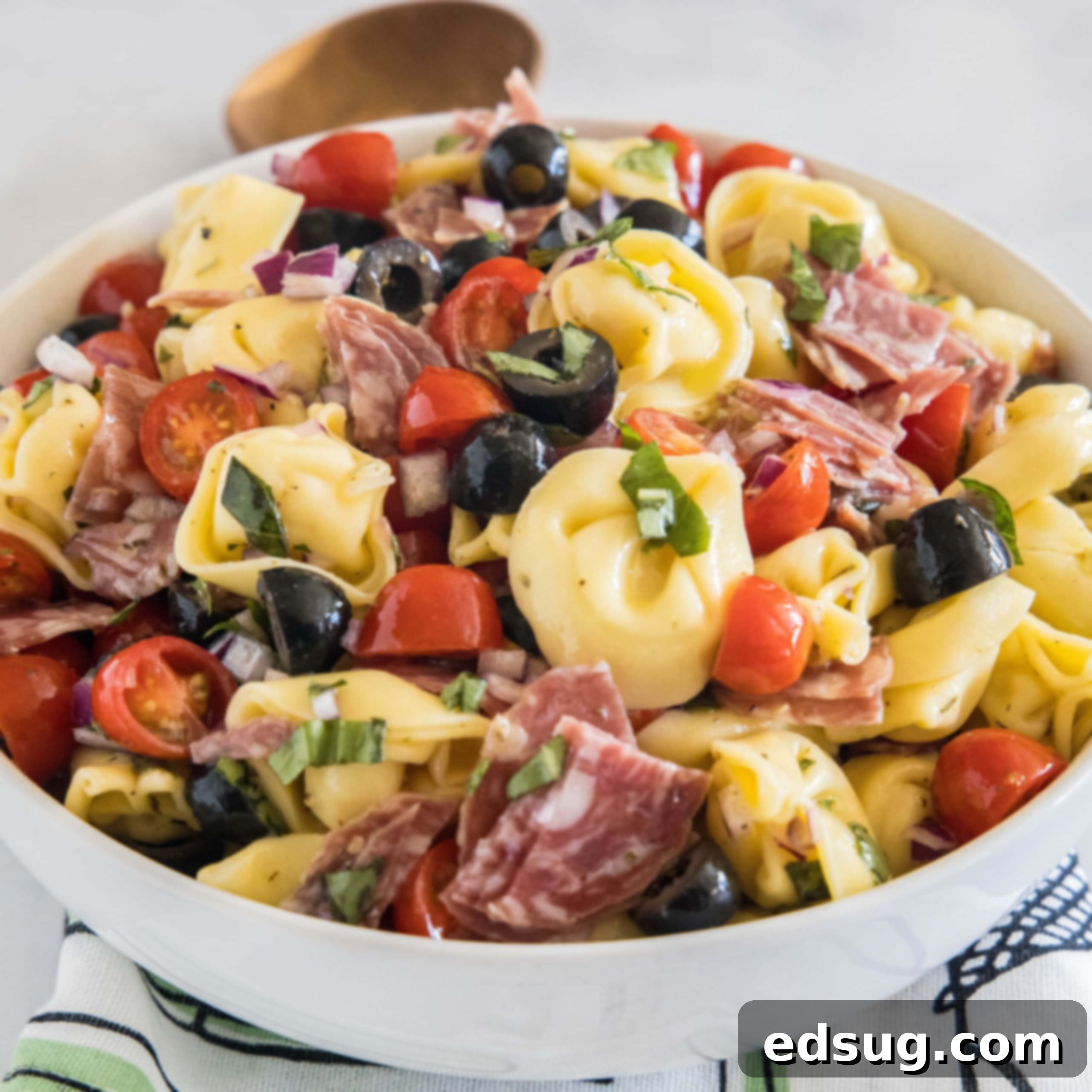 Tortellini pasta salad in a white bowl.