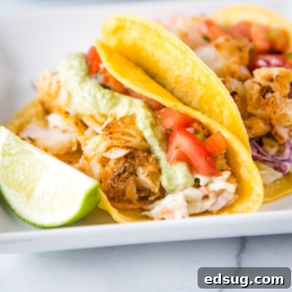 A plate of vibrant fish tacos with various fresh toppings, alongside a side of salsa.