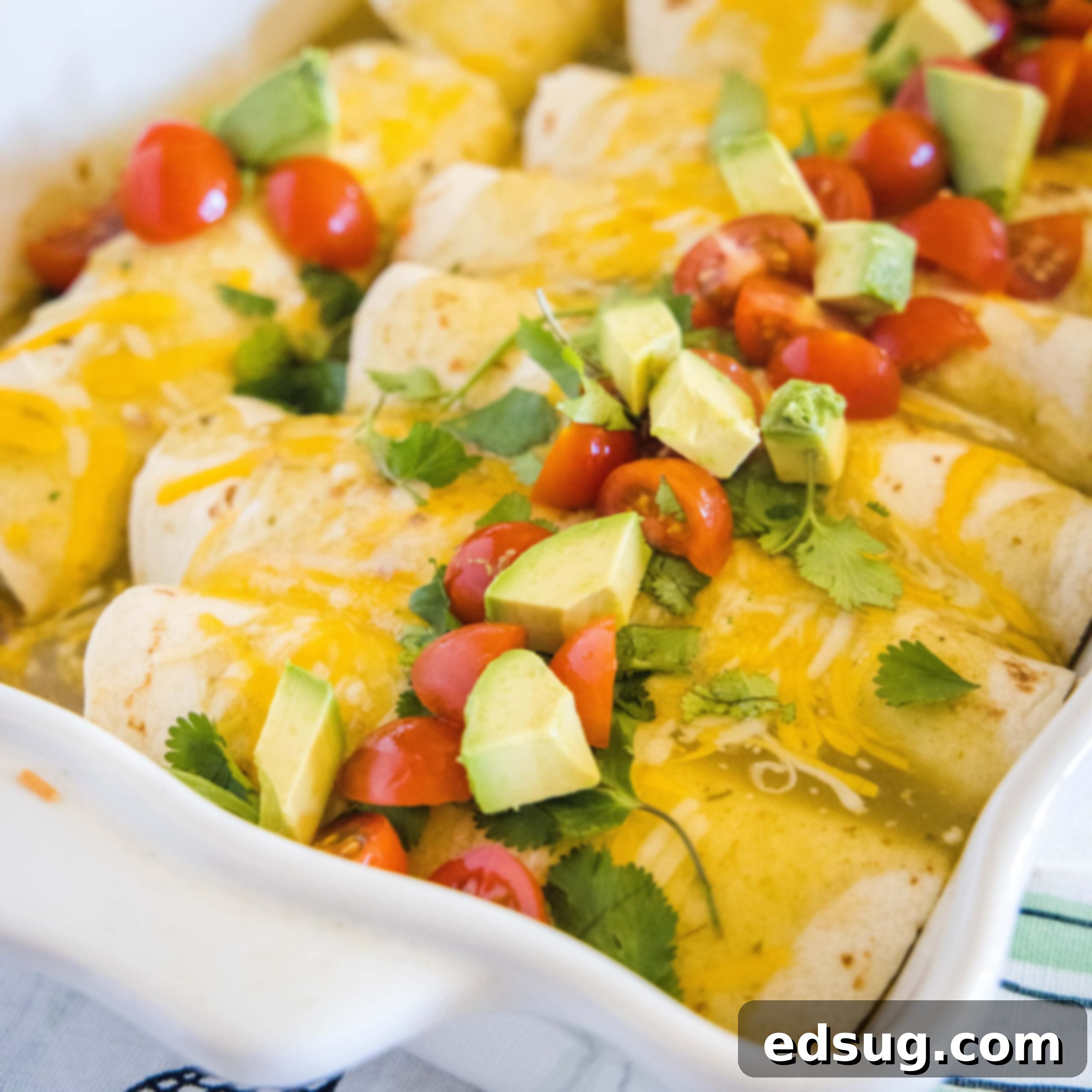 Close up of delicious breakfast enchiladas, beautifully topped with fresh avocado and diced tomatoes.