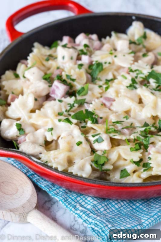 Chicken Cordon Bleu Pasta in a white bowl with a fork