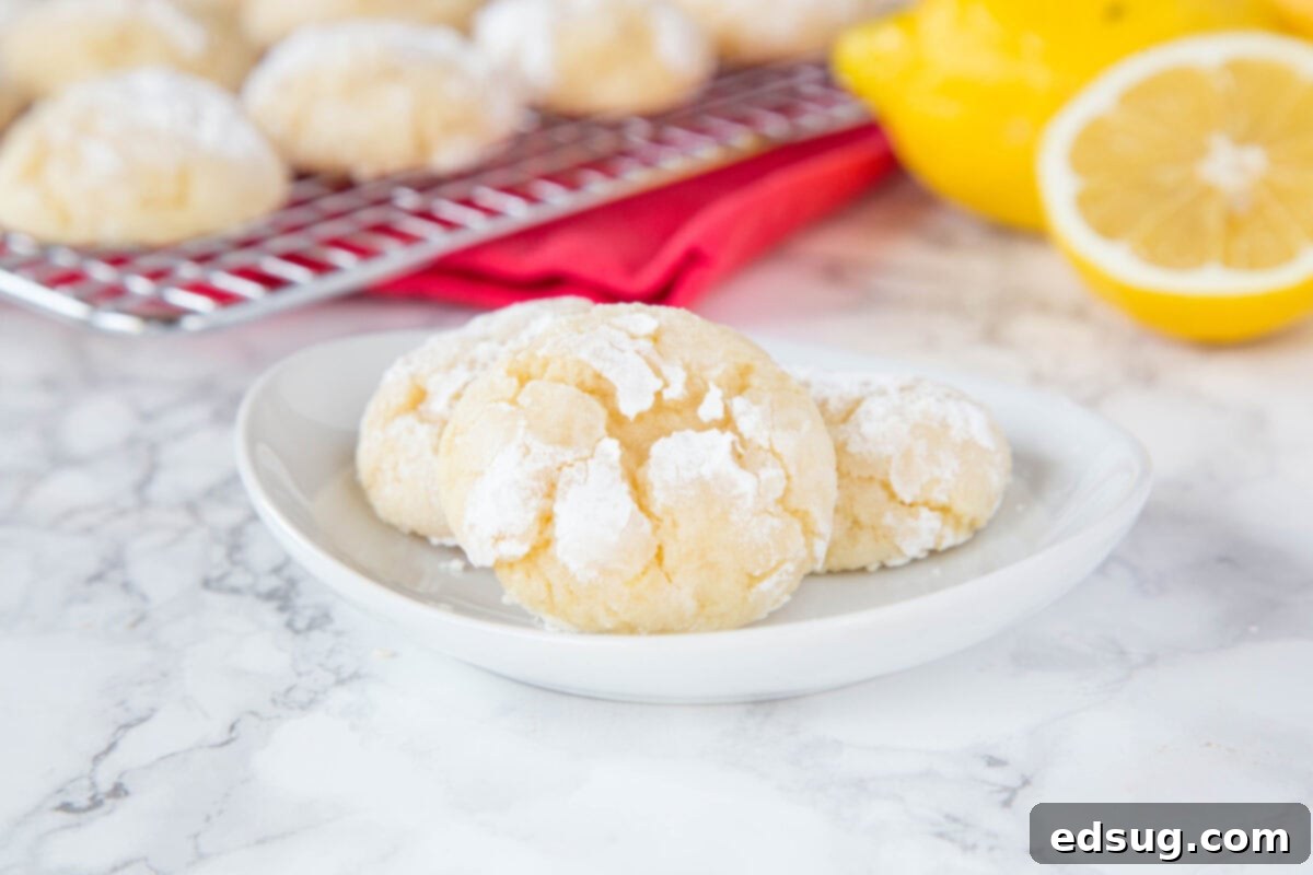 Freshly baked lemon crinkle cookies cooling on a wire rack