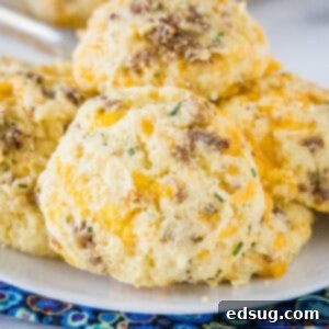 Cheesy Sausage Biscuit 6 Close up image of golden-brown cheese and sausage biscuits on a plate, showcasing their inviting texture.