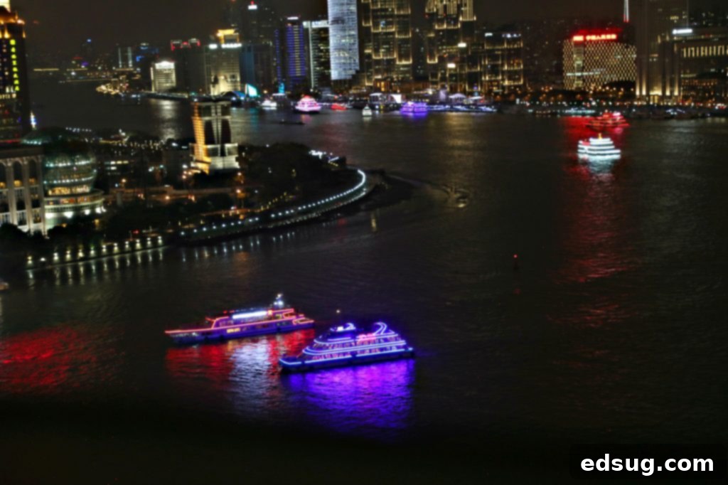 10 Unmissable Shanghai Experiences 12 The illuminated Shanghai skyline at night, as seen from a Huangpu River cruise, with vibrant lights reflecting on the water.
