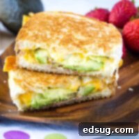 Cropped square image of a delicious avocado grilled cheese sandwich, cut in half and ready to serve.