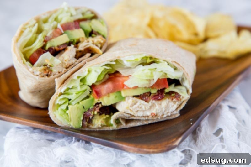 Two Chicken Club Wraps, sliced in half and arranged on a serving plate, ready to be enjoyed.