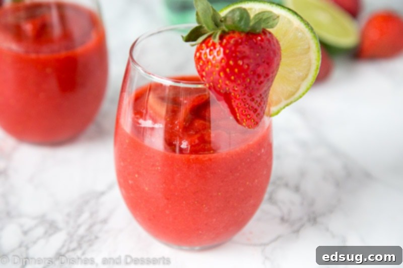 Frosted Strawberry Daiquiri 3 Close-up of a chilled Frozen Strawberry Daiquiri, garnished with fresh fruit, ready to be enjoyed.