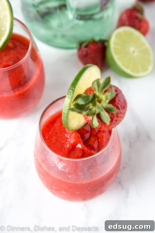 Frosted Strawberry Daiquiri 4 A vibrant Frozen Strawberry Daiquiri, garnished with a strawberry, ready to be enjoyed.