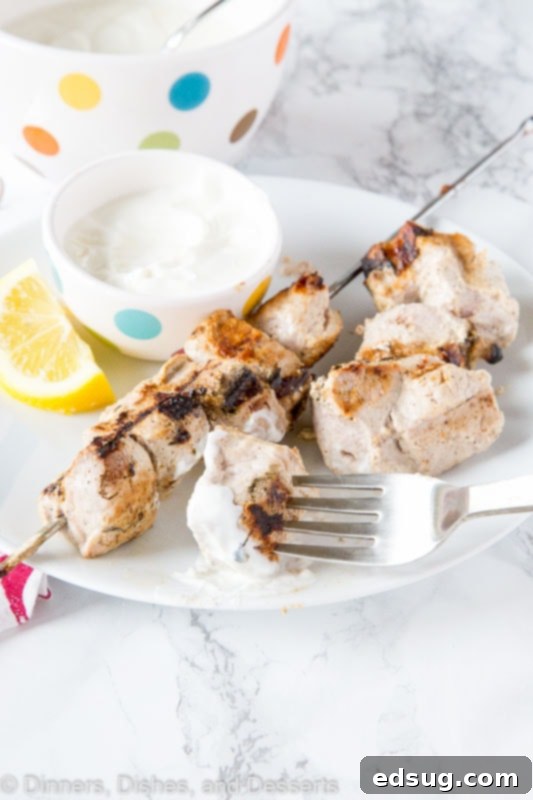 Tender Yogurt-Marinated Pork Kebabs 2 A plate of food with a fork, with pork kebabs