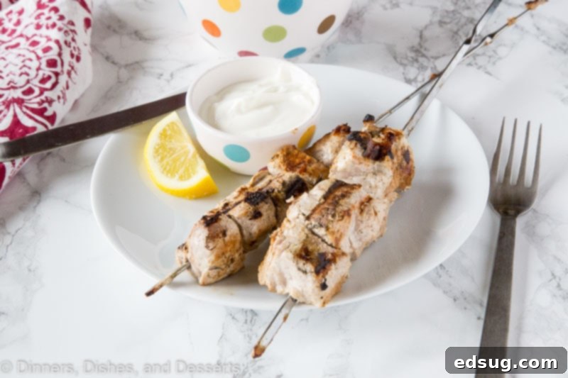 Tender Yogurt-Marinated Pork Kebabs 3 A plate of food with a fork and knife, with Yogurt and Pork