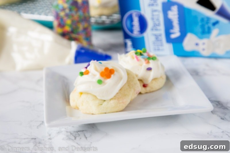 Sparkle-Topped Funfetti Cake Mix Cookies 4 A stack of delightful Funfetti Cake Mix Cookies, beautifully frosted and adorned with an abundance of colorful sprinkles, presented on a white plate, inviting a sweet indulgence.