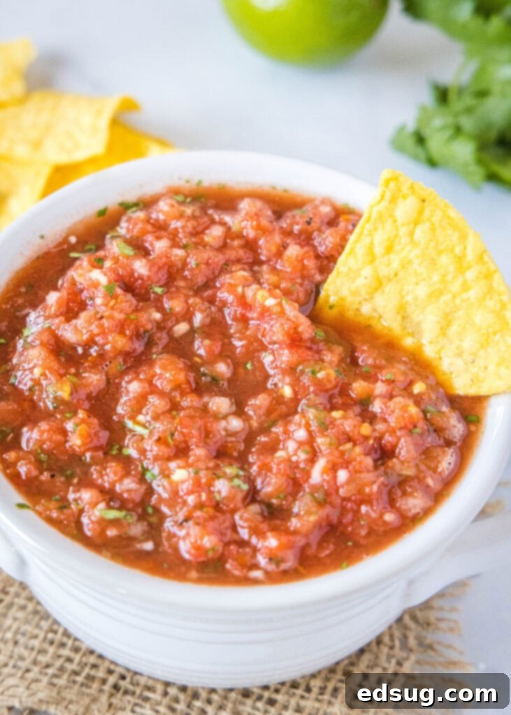 salsa in a white bowl with a chip in it