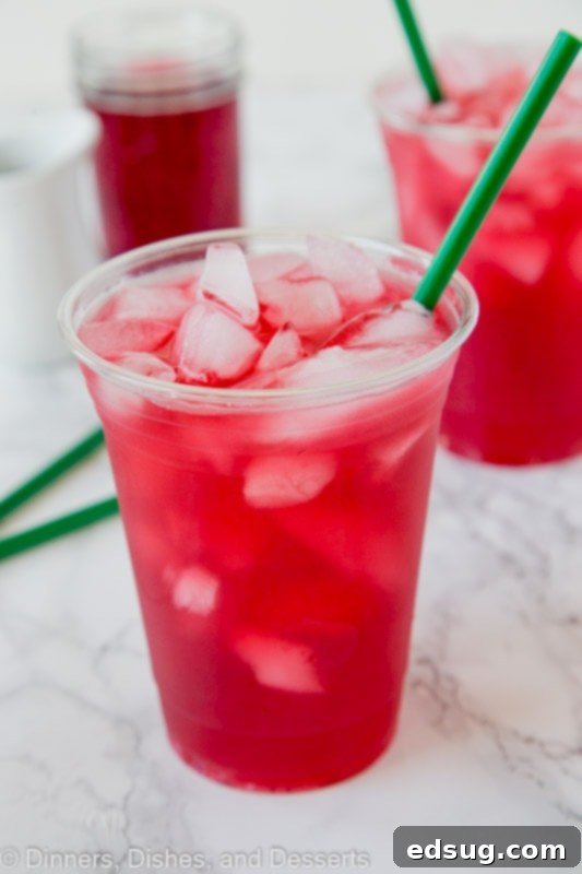 A close-up of three glasses of Passion Tea Lemonade, garnished with lemon slices