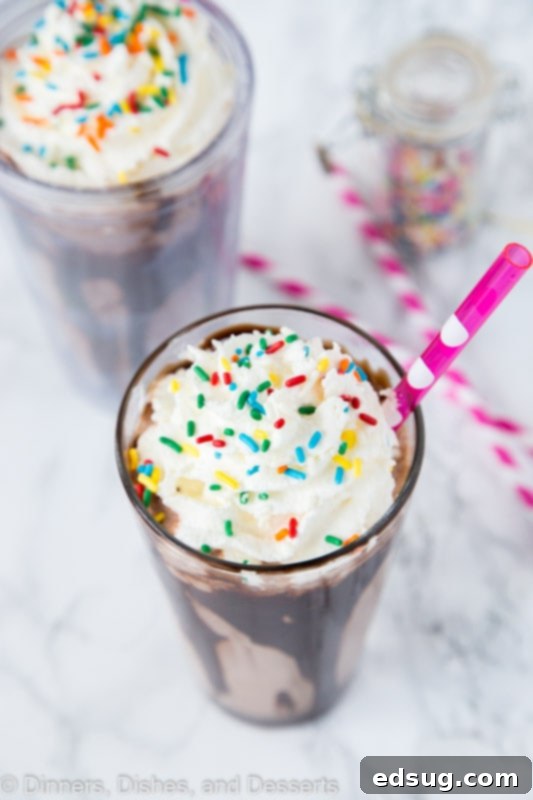 Decadent Chocolate Milkshake Delight 4 Enjoying a homemade chocolate milkshake topped with whipped cream and sprinkles is the perfect summer treat!