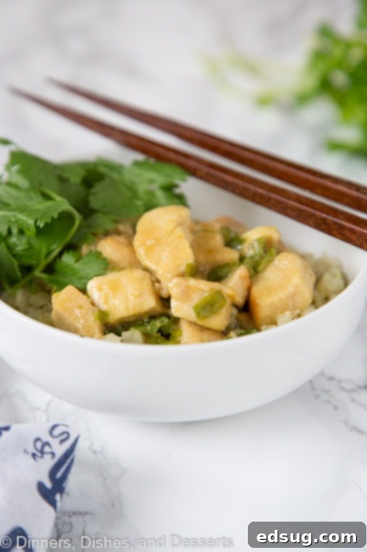 Close-up of vibrant green curry chicken with sauce in a skillet