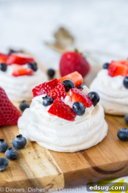 Easy Mini Pavlova Recipe 2 A close up of pavlova with berries, highlighting its crispy texture and fresh fruit topping.