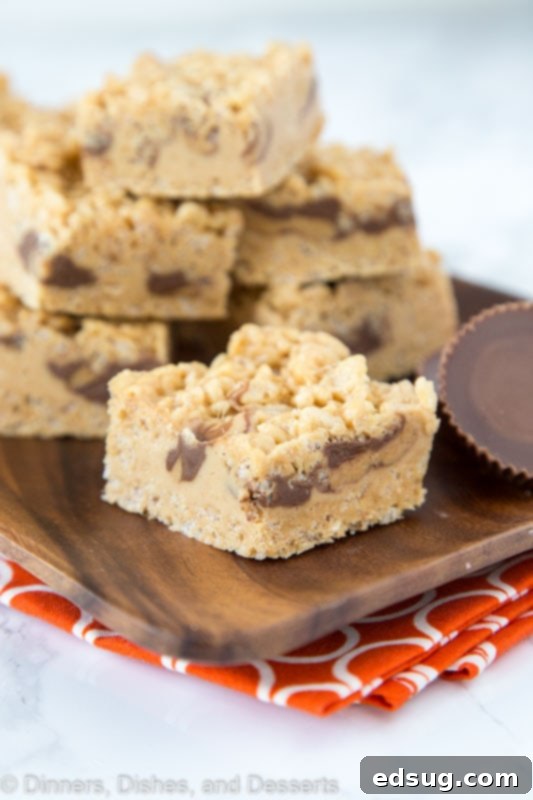 Peanut Butter Rice Krispie Delights 3 krispie treats with peanut butter and peanut butter cups on tray