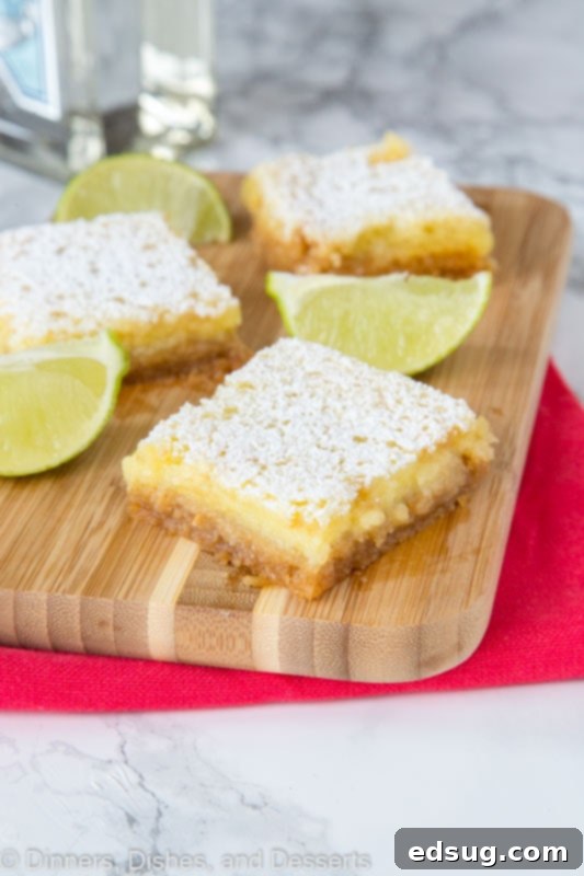 Zesty Lime Margarita Bars 4 sliced margarita bars on a cutting board with lime wedges