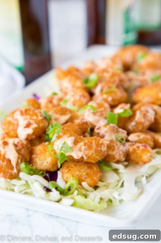Crispy Bang Bang Shrimp with Sweet Chili Sauce 2 A close up of a plate of crispy Bang Bang Shrimp, garnished with fresh herbs.