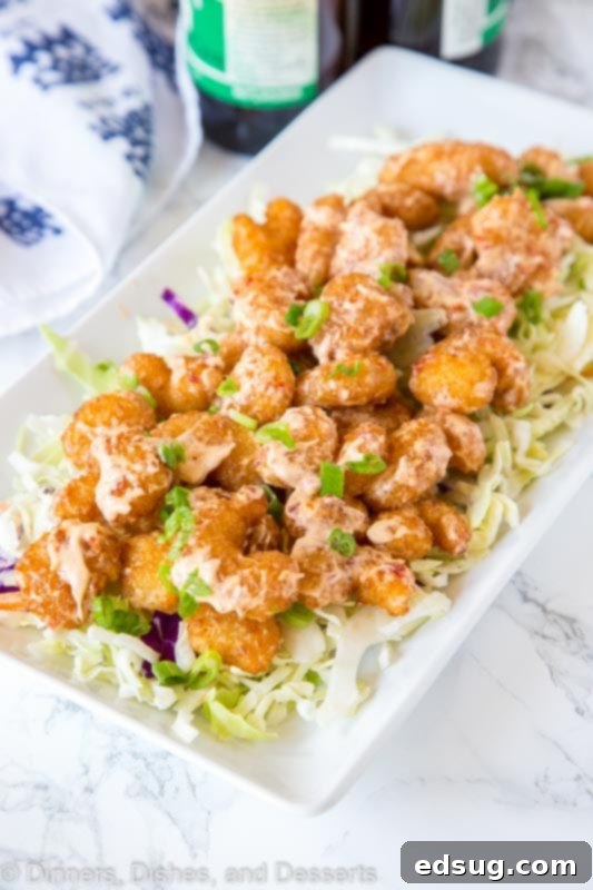 Crispy Bang Bang Shrimp with Sweet Chili Sauce 3 A plate of golden-brown crispy fried shrimp coated in Bang Bang sauce.