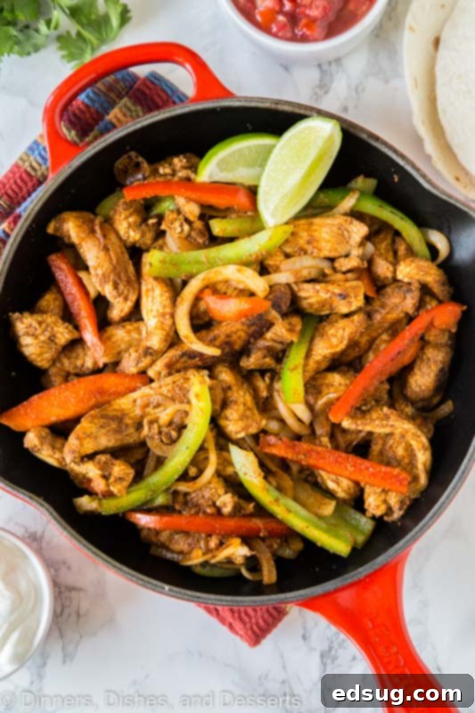 Sizzling chicken fajitas with colorful bell peppers and onions in a cast-iron skillet, ready to serve.
