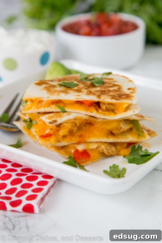 Chicken Fajita Quesadilla Supreme 4 A perfectly cooked chicken fajita quesadilla, golden brown and crispy, sliced into wedges.