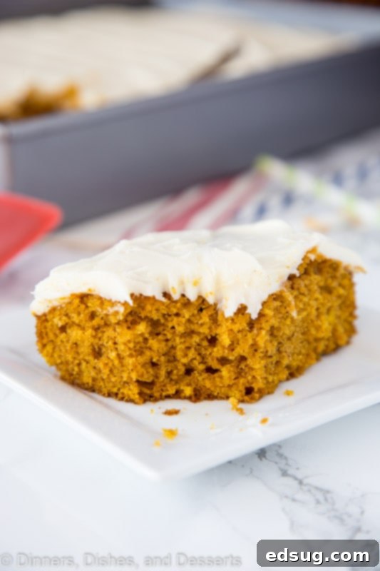 A close-up of a delicious piece of pumpkin cake on a paper plate, showcasing its soft texture.