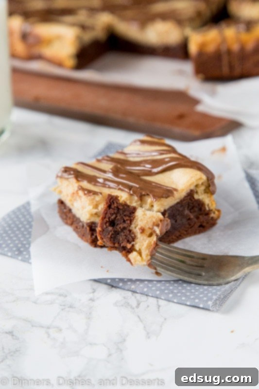 Decadent Peanut Butter Cheesecake Brownies 4 Peanut butter cheesecake brownie on a table with a bite on the fork
