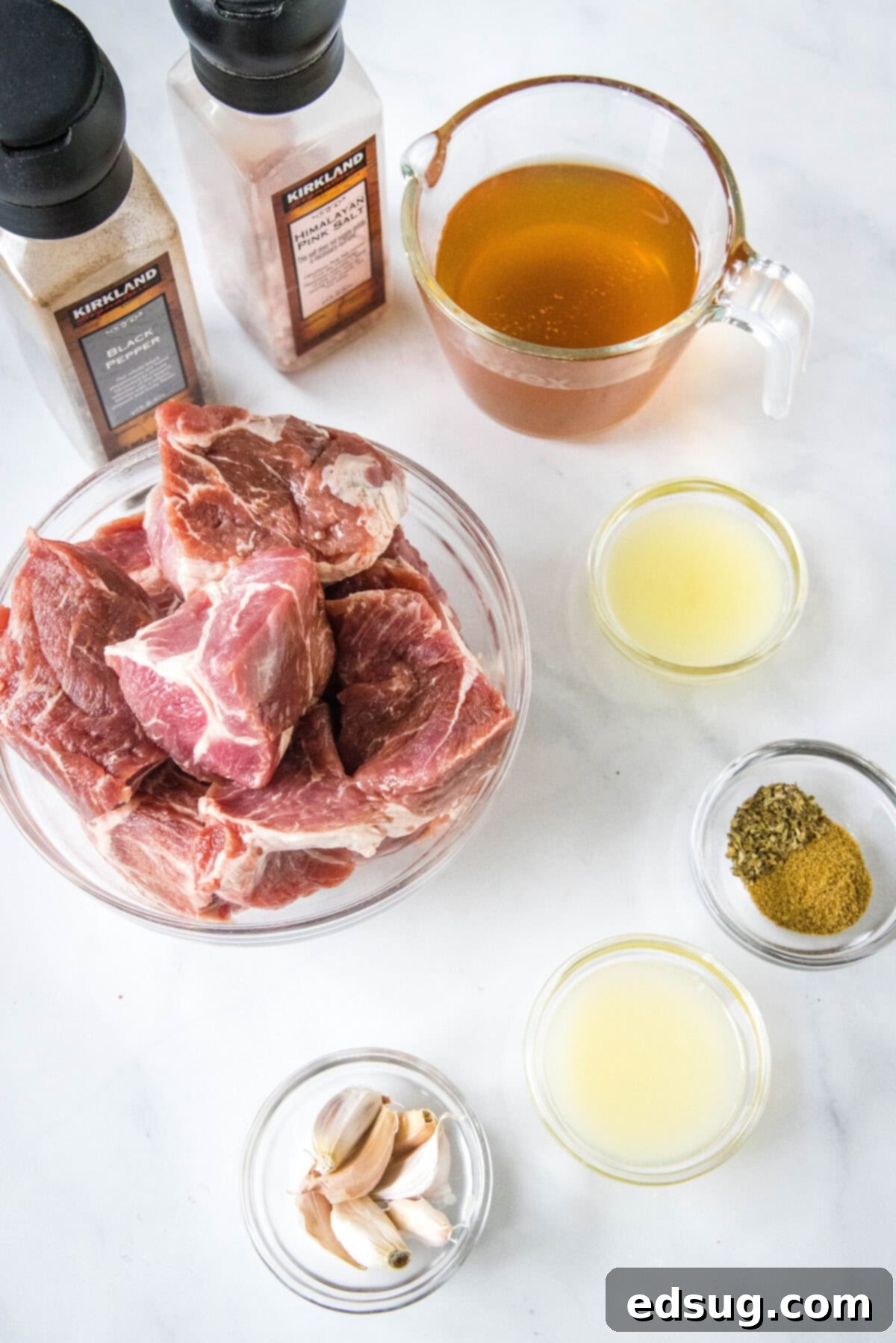 Instant Pot Pork Taco Perfection 3 Various ingredients for Instant Pot Pork Tacos laid out, including pork shoulder, limes, lemon, garlic, broth, and spices.