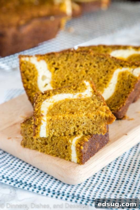 A slice of pumpkin bread with cream cheese swirl cut in half