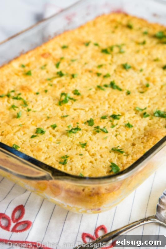 Golden brown corn casserole in a white baking dish, fresh out of the oven and ready to serve for a holiday meal.