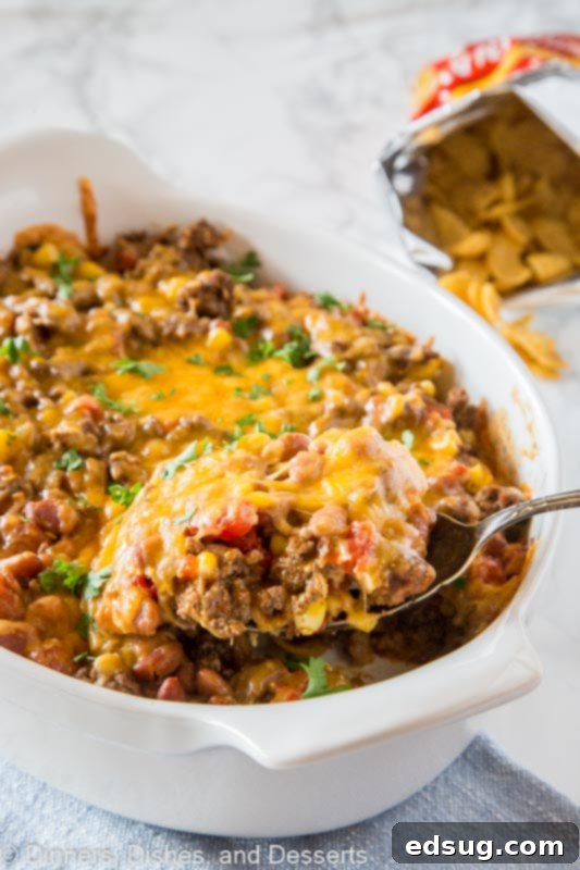 Classic Frito Pie Recipe 2 A hearty bowl of taco meat with melted cheddar cheese, ready to be layered for Frito Pie.
