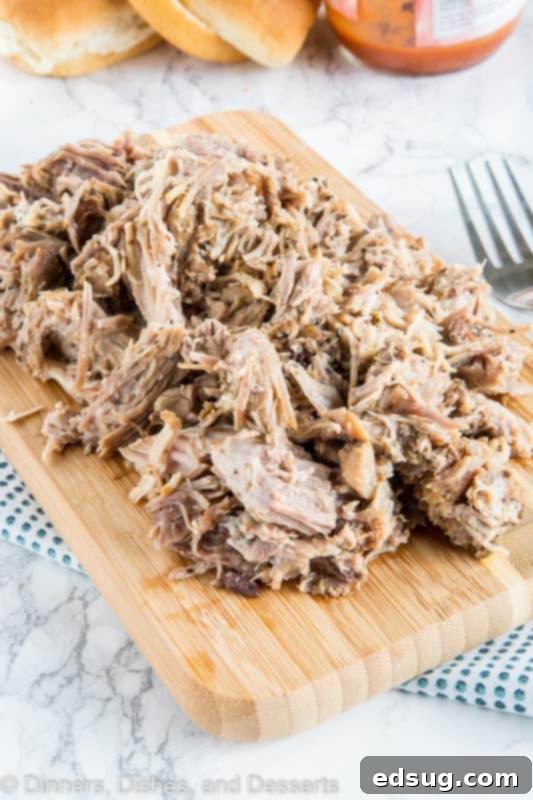 A close up of food on a table, with Pork and Pulled pork, ready to be served on buns