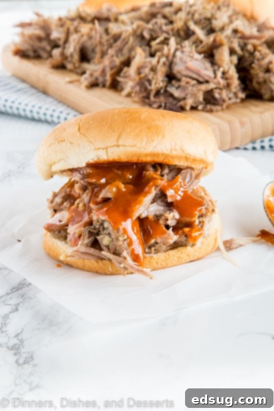 A delectable pulled pork sandwich on a paper plate, perfect for dinner