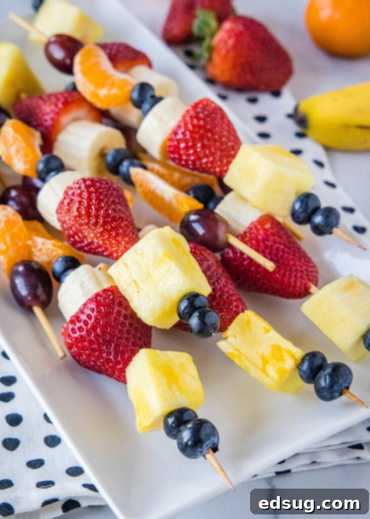 Colorful Fruit Skewers 2 fruit skewers on a white plate
