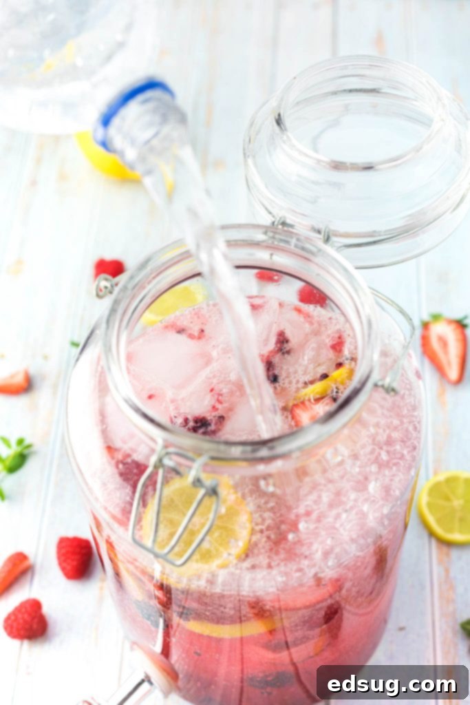 pouring sparkling water into a pitcher of lemonade