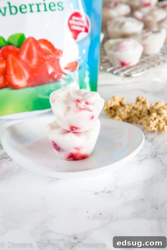 Homemade Frozen Yogurt Cups 4 A stack of perfectly frozen yogurt cups with berries, showcasing their appealing texture and snack-ready form.