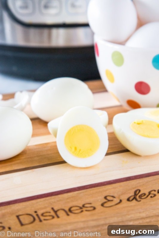 A close-up shot of a perfectly cooked hard-boiled egg, sliced in half, revealing a smooth, bright yellow yolk.