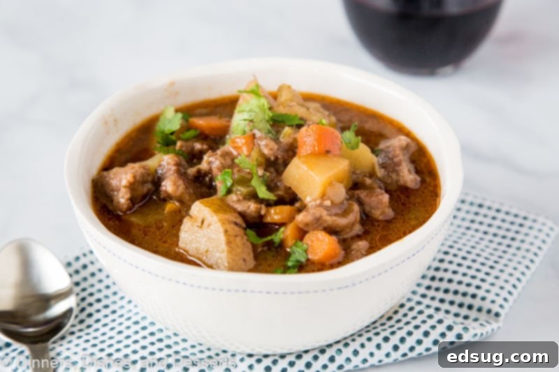 Hearty Instant Pot Beef Stew 5 A bowl of food on a plate, with Stew and Beef