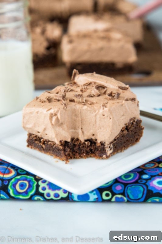 Decadent Chocolate Mousse Brownies 2 Chocolate Mousse Brownies with a bite taken out, showing the layers of fudgy brownie and fluffy mousse.