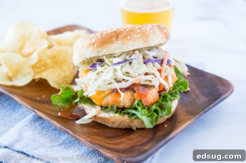 Close-up of a Buffalo Chicken Burger showing the textured patty, melted cheese, and creamy slaw.