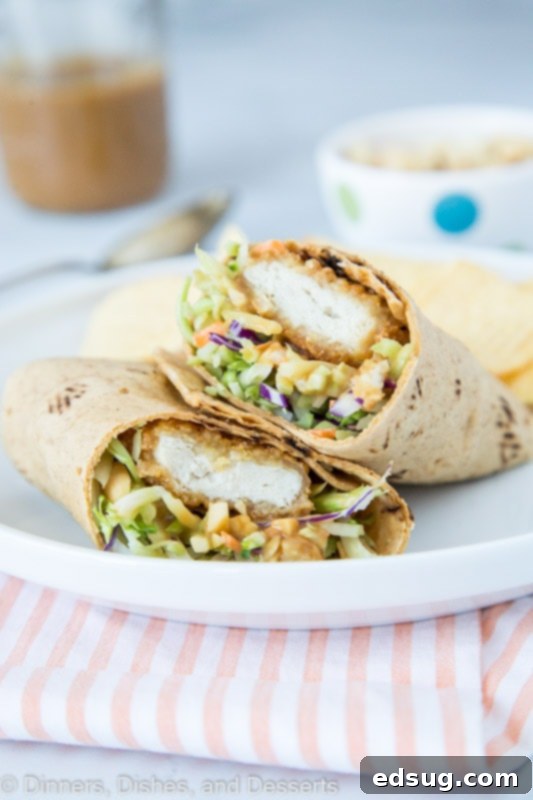 Flavorful Asian Chicken Lettuce Wraps 2 Asian Chicken wrap with thai peanut sauce, sliced in half to show the filling.