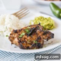 Fiery Jamaican Jerk Chicken 7 A plate of grilled jerk chicken with rice and vegetables