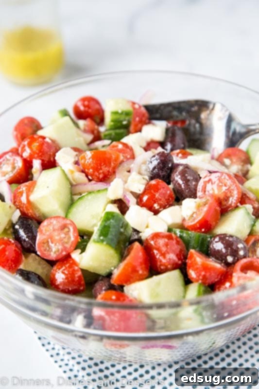 Close-up of fresh cucumber, tomato, red onion, Kalamata olives, and feta cheese, ready for the Greek dressing